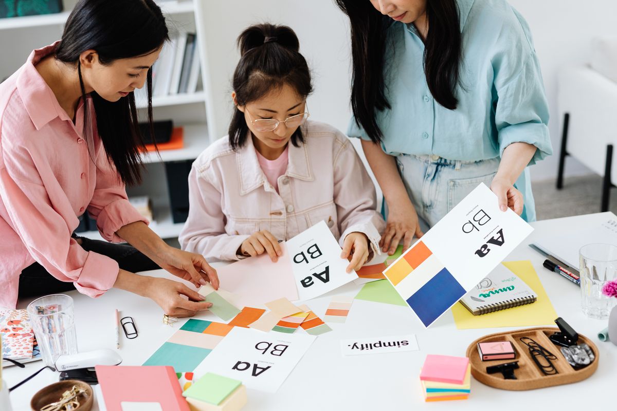 Three colleagues laying out colour swatches and type samples