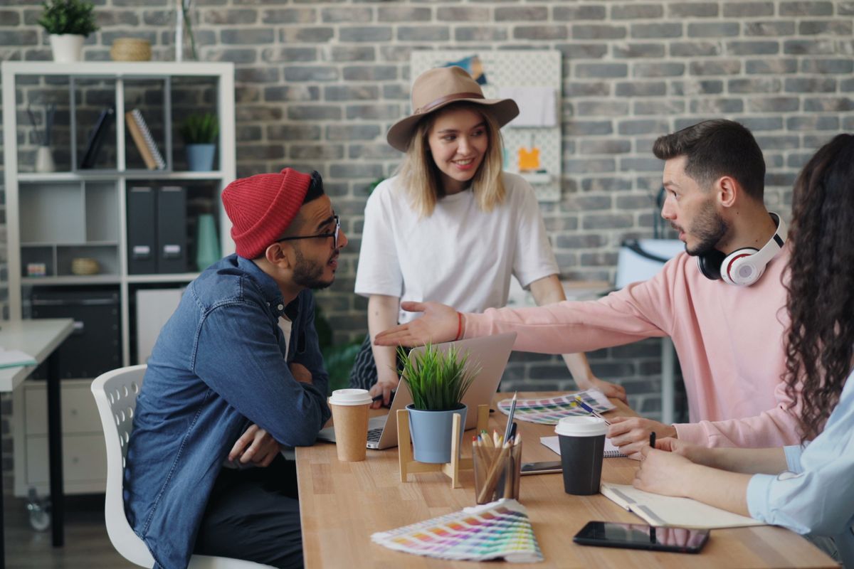 A small team talking through colour references around a studio desk